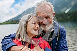 Portrait of beautiful active senior couple hiking together in autumn mountains.