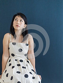 Portrait of a beautiful adult Asian woman 40-year-old with short black hair wearing a polka dot dress, Sitting and pretending