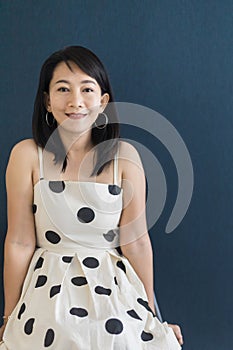 Portrait of a beautiful adult Asian woman 40-year-old with short black hair wearing a polka dot dress, Sitting and pretending