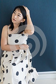 Portrait of a beautiful adult Asian woman 40-year-old with short black hair wearing a polka dot dress, Sitting and pretending