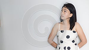 Portrait of beautiful adult 40 years old Asian woman in polka dots dress with arms crossed and pretending straight face over