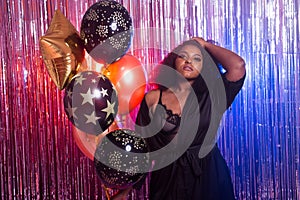 Portrait of a beautiful african american woman against twinkling background. Birthday party, nightclub and nightlife