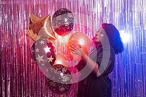 Portrait of a beautiful african american woman against twinkling background. Birthday party, nightclub and nightlife