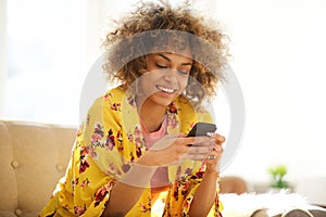 Beautiful african american woman using cellphone at home photo