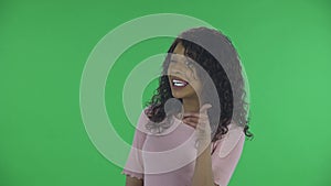 Portrait of beautiful african american young woman is looking at camera winks coquettishly and points fingers at someone