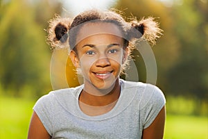 Portrait of beautiful African girl sitting in park