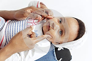 Portrait of beautiful african woman holding on hands her little baby