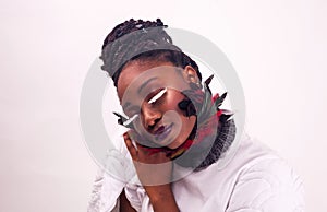 Portrait of a beautiful African woman. Studio with white background. Make up with lashes made of feathers. Fashion style