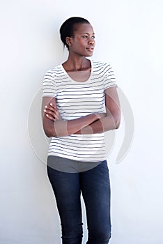 Beautiful afro american woman standing with arms crossed against white wall and looking away