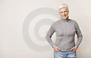 Portrait of beautiful aged woman on light studio background