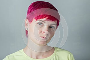 Portrait of a beautiful angry woman with short pink hair