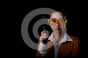 Portrait beautiful asea woman wearing a yellow suit one hand holding a pistol gun at black background