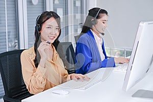 Portrait beautiful asia two women working call center operator with headset in office or workplace