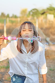 Portrait beautiful asia woman blowing bubbles outdoor, select focus on face
