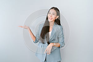 Portrait of beautiful Asian businesswoman presenting or showing open hand palm with copy space for product isolated green pastel