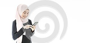 Portrait of beautiful asian muslim woman in a black hijab smiling and using mobile phone isolated over white background