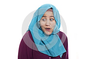 Portrait of beautiful Asian muslim woman wearing hijab happy surprised with mouth opened, looking to the side