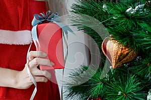 Portrait beautiful asian woman holding gift box in hand and wearing red Santa Claus outfit and smiling happily,concept Christmas