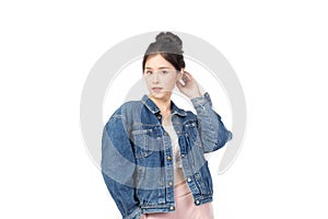 Portrait of beautiful asian woman model in white T-shirt, dressed in denim jacket posing while standing and looking at camera