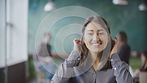 Portrait of beautiful Asian woman in modern office. Young successful businesswoman looking at camera, smiling.