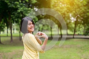 Portrait of beautiful asian woman showing hands heart shape at outdoor,Happy and smiling,Positive thinking