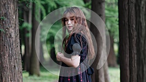 Portrait of beautiful Asian woman standing in summer forest, Chinese girl in vintage black dress looking at camera