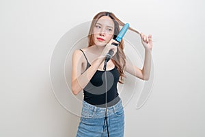 Portrait beautiful Asian woman using hair curler or curling iron