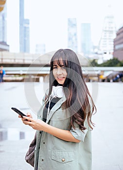 Portrait beautiful asian woman using mobilephone and walking in the city,Female confidence happy and smiling,Lifestyle concept