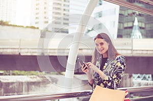 Portrait beautiful asian woman walking and holding mobilephone in the city,Happy and smiling