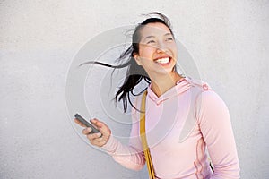 Beautiful asian woman walking outside with mobile phone and smiling