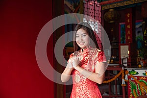 Portrait of a beautiful Asian woman wearing a red cheongsam Pay respects and ask for blessings inside the shrine