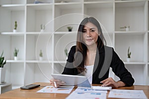 Portrait beautiful asian woman working about financial with business report and calculator. financial or accounting