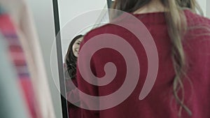 Portrait of beautiful attractive Asian woman combing her hair and choosing clothes in her dressing room at home.