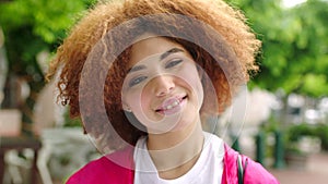 Portrait of a beautiful and attractive stylish female smiling on a summer afternoon standing outside. Happy edgy lady
