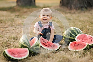 Portrait of beautiful baby girl eating watermelon. Child eating watermelon in the garden. Adorable little girl playing
