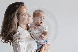 Portrait of a beautiful baby girl and her mother at home. Family concept indoors. Daytime and lifestyle