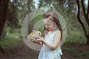 Portrait of a beautiful baby girl with a red rabbit