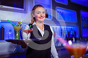 Portrait of beautiful bartender holding serving tray