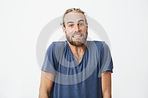 Portrait of beautiful bearded guy with trendy haircut funny posing for article university newspaper. Face expressions