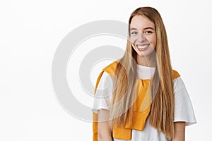 Portrait of beautiful blond woman with long. natural straight hair, white perfect smile, looking happy at camera