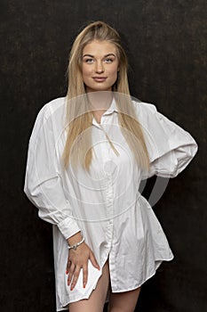 Portrait of a beautiful blonde girl 20-25 years old with long hair on a dark background.