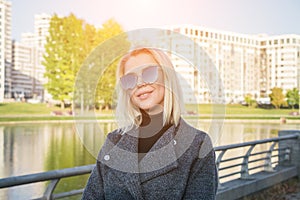 Portrait of a beautiful blonde girl on a background of a modern residential area
