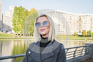 Portrait of a beautiful blonde girl on a background of a modern residential area