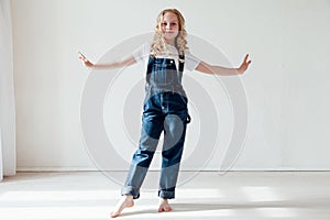 Portrait of a beautiful blonde girl in a denim jumpsuit