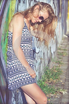 Portrait of a beautiful blonde girl near the wall