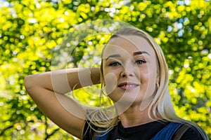 Portrait of a beautiful blonde in the park. Young pretty caucasian woman walking in a summer sunny day