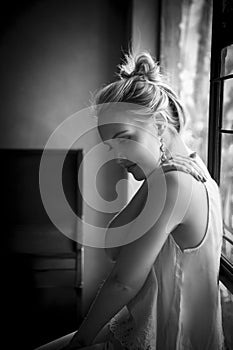 Portrait of beautiful blonde woman lost in thought in black and white monochrome