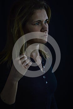 portrait of a beautiful blonde woman playing with her hair while deep in thought