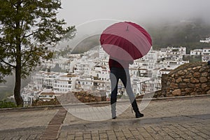 Portrait of beautiful blonde woman with red umbrella