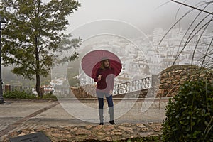 Portrait of beautiful blonde woman with red umbrella